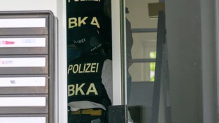 Polizisten vom Bundeskriminalamt (BKA) gehen im Treppenhaus eines Wohnhauses zu einer Durchsuchung hinauf zu einer Wohnung. Ein Mitarbeiter eines deutschen Europaabgeordneten ist in Dresden wegen des Verdachts der Spionage für China festgenommen worden…