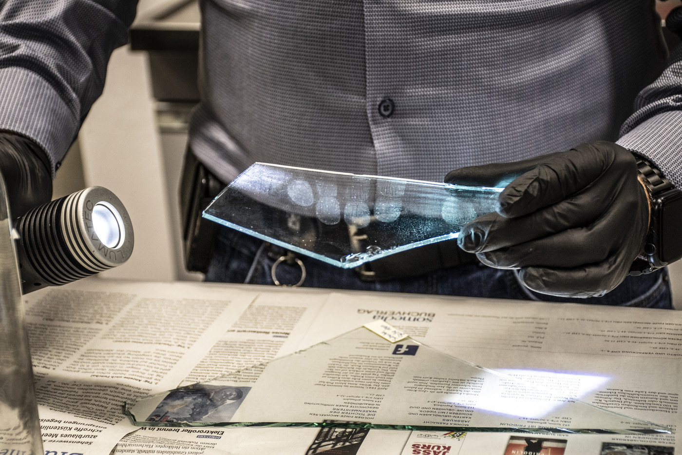 Gut erkennbar: Mit der Spurenlampe werden die Fingerabdrücke auf einer Scherbe der Fensterscheibe sichtbar. Bild Riccarda Hartmann