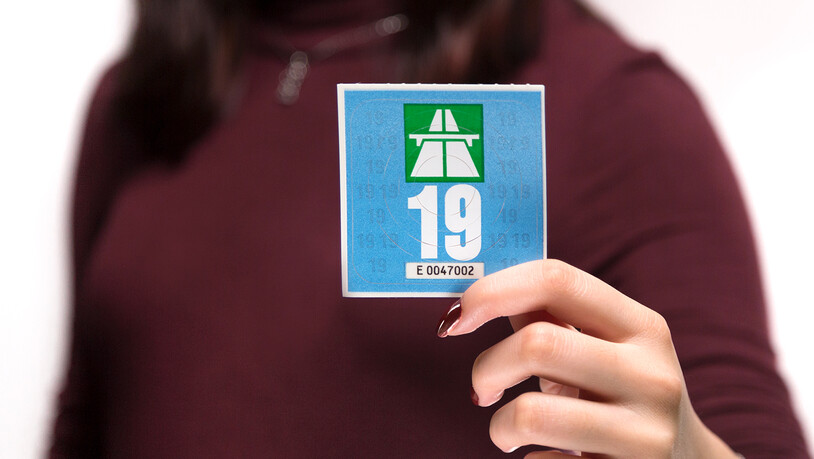 Das ist die Autobahnvignette 2019 - stilvoll präsentiert von einer Frau mit passendem Nagellack zum Pullover.