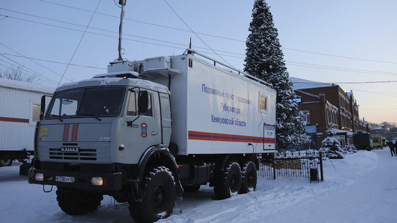 Ein Lastwagen des russischen Katastrophenschutzministeriums steht in der Listwjaschnaja-Mine (rechts) in der Nähe von Belowo in der Region Kemerowo im Südwesten Sibiriens, Russland. Foto: Sergei Gavrilenko/AP/dpa