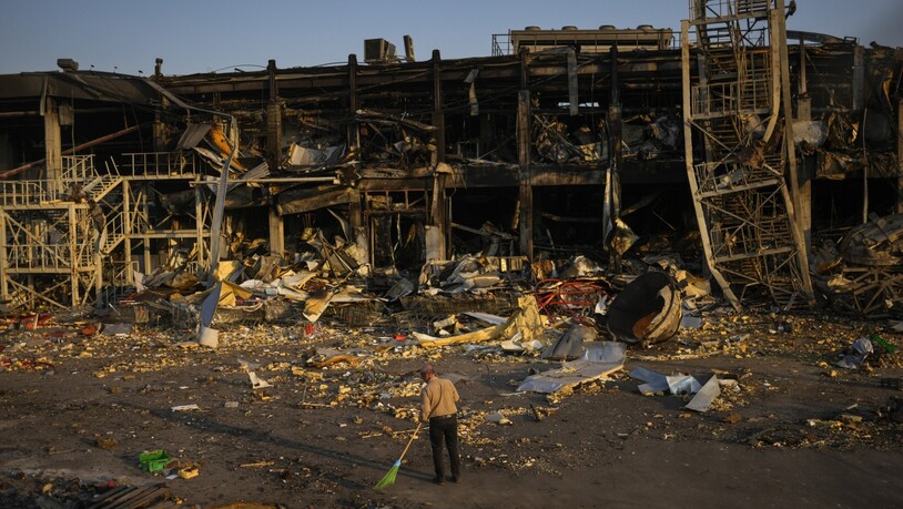 Ein Mann fegt in Odessa die Trümmer zusammen. Das Einkaufzentrum wurde am 9. Mai durch einen russischen Raketenangriff zerstört. Foto: Francisco Seco/AP/dpa