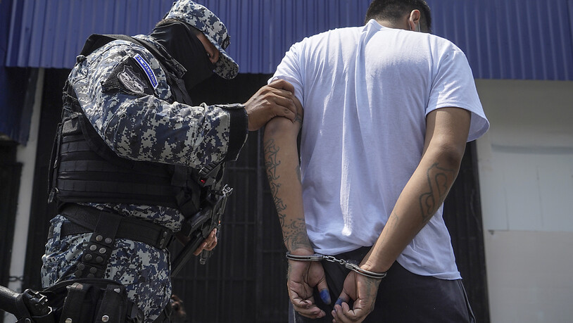 ARCHIV - Ein vermummter Polizist begleitet einen mutmaßlichen Bandenmitglied nach dessen Festnahme. Foto: Camilo Freedman/dpa