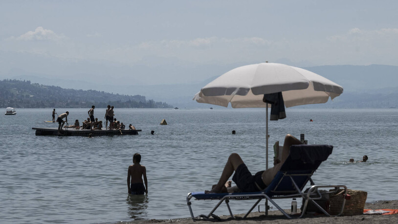 Menschen geniessen das sommerliche Wetter im Strandbad Mythenquai in Zürich.