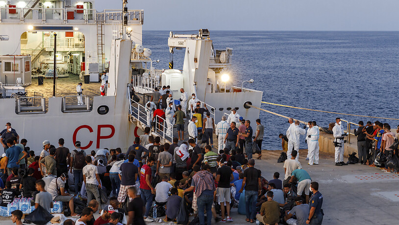 ARCHIV - Migranten warten an Bord eines Schiffes der italienischen Küstenwache auf der sizilianischen Insel Lampedusa. Foto: David Lohmueller/AP/dpa