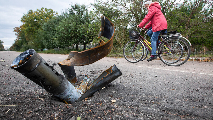 Einheimische fahren mit ihren Fahrrädern an einer explodierten Rakete auf der Hauptstraße in der Stadt Balaklija vorbei, die kürzlich von den ukrainischen Streitkräften in der Region Charkiw zurück erobert wurde. Russische Truppen besetzten die Stadt…