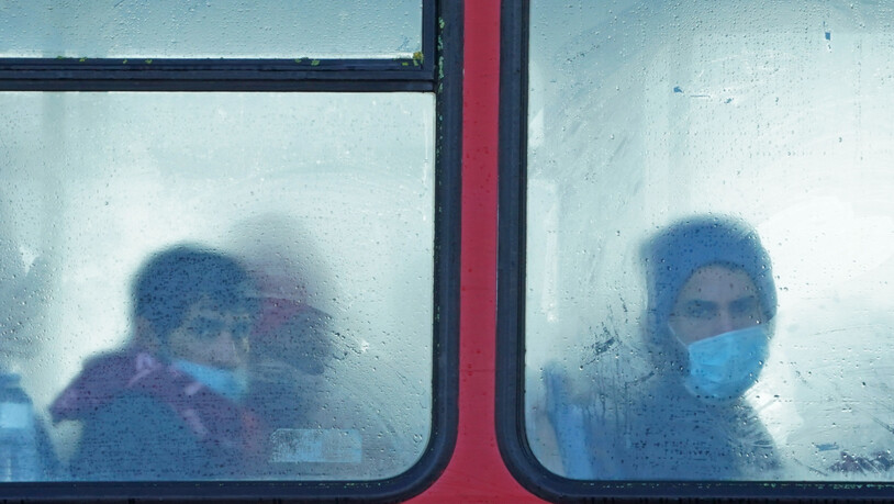 ARCHIV - Eine Gruppe von Menschen, bei denen es sich vermutlich um Migranten handelt, sitzt in einem Bus. Am 24.11.2021 starben mindestens 27 Migranten auf dem Weg nach Großbritannien, als ihr Boot im Ärmelkanal sank. Foto: Gareth Fuller/PA Wire/dpa