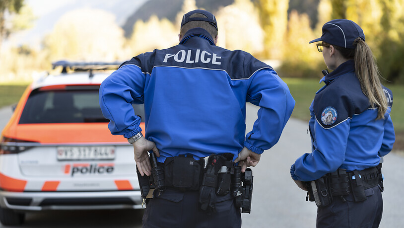 Ein Polizist und eine Polizistin der Walliser Kantonspolizei im Einsatz. (Archivbild).