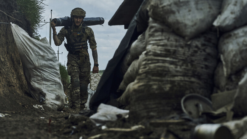 dpatopbilder - Ein ukrainischer Soldat trägt Vorräte in einem Graben an der Frontlinie bei Bachmut (Archivbild). Foto: LIBKOS/AP