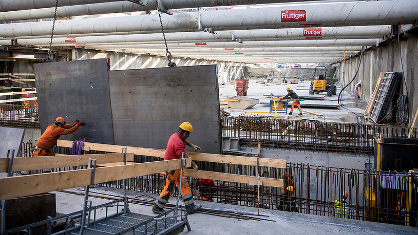 Männer arbeiten auf einer Baustelle für den Bau eines unterirdischen Autobahnabschnittes in Rarogne. Im ersten Quartal 2023 wurden in der Schweiz erneut mehr Stellen geschaffen. (Symbolbild)