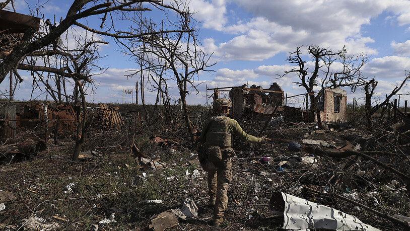 dpatopbilder - Ein Soldat zeigt auf ein zerstörtes Haus an der Frontlinie. Die Brigade gab bekannt, dass sie die vom Krieg zerstörte Siedlung, die 10 Kilometer südlich der von Russland besetzten Stadt Bakhmut im umkämpften Osten des Landes liegt,…