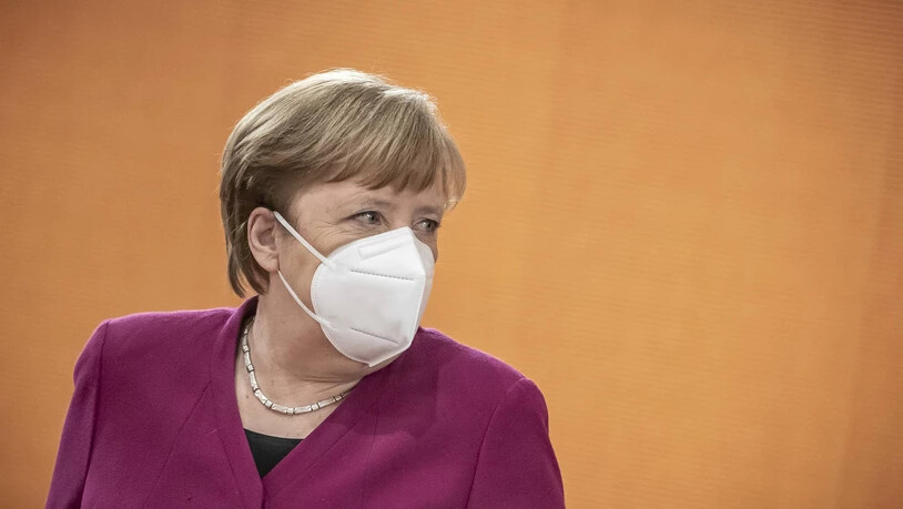 German Chancellor Angela Merkel takes off her mask at the beginning of the Federal Cabinet meeting at the Chancellery in Berlin, Germany, Wednesday, March 3, 2021. (Michael Kappeler/Pool via AP) Germany Politics