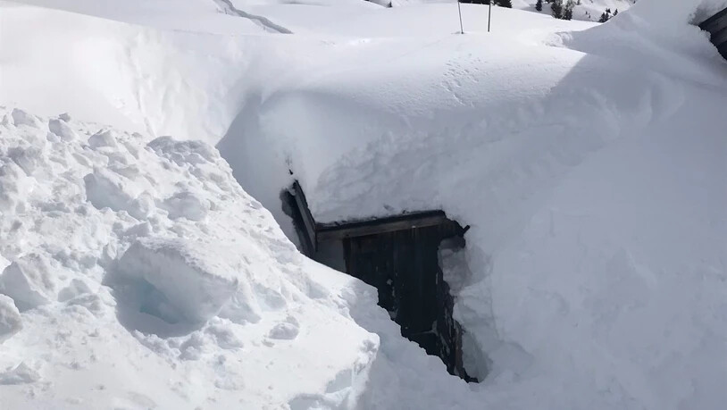 Eine Dachlawine verschüttete ein Abgasrohr vor einer Skihütte-.