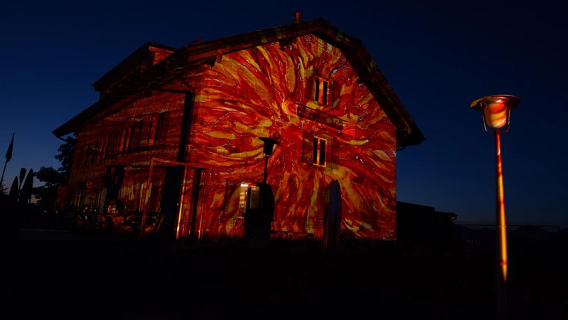 Licht-Artist Gerry Hofstetter schiebt vor dem Naturfreundehaus ein neues Dia in den Wechselrahmen seines riesigen Projektors. 