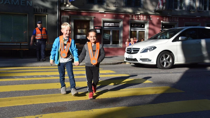 Verkehrserziehung: Polizist Christian Eggenberger weist die Kindergärtler auf die Gefahren im Strassenverkehr hin.