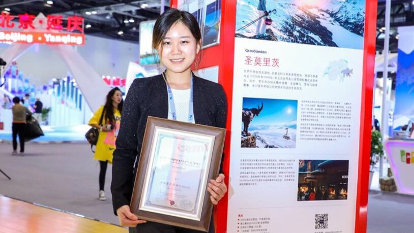 Projektmanagerin Qingyang Liu mit der Auszeichnung für St. Moritz in Peking.