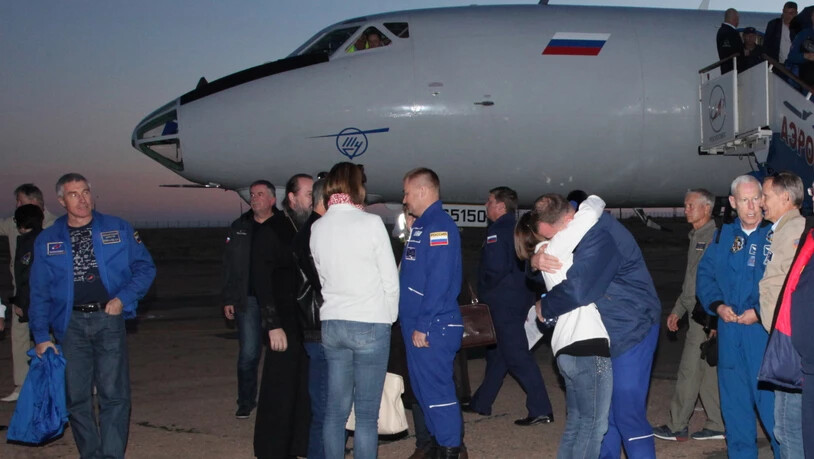 Wohlauf: US-Astronaut Nick Hague wird bei seiner Ankunft am Flughafen von Baikonur umarmt. In der Bildmitte sein russischer Kollege Alexej Owtschinin.