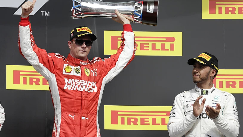 Kimi Räikkönen mit Siegerpokal, Lewis Hamilton applaudiert artig
