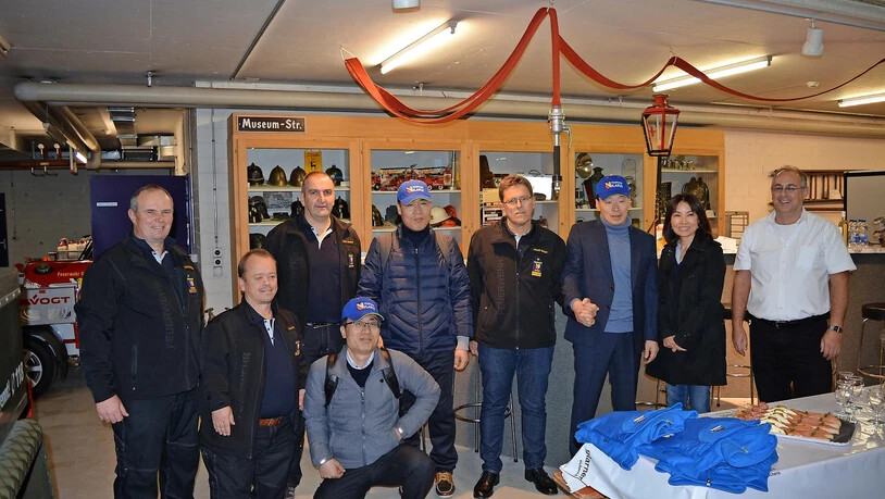Gruppenbild mit Schlauch - und Dame. Die Delegation aus Südkorea lässt sich mit den Glarnern ablichten.