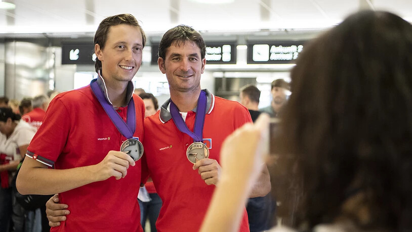 Martin Fuchs (links) und Steve Guerdat präsentieren ihre WM-Medaillen nach der Heimkehr von Tryon.
