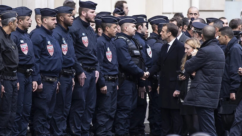 Stark unter den Druck der Strasse geraten: Frankreichs Präsident Emmanuel Macron mit Einsatzkräften gegen gewalttätige Ausschreitungen am Sonntag.