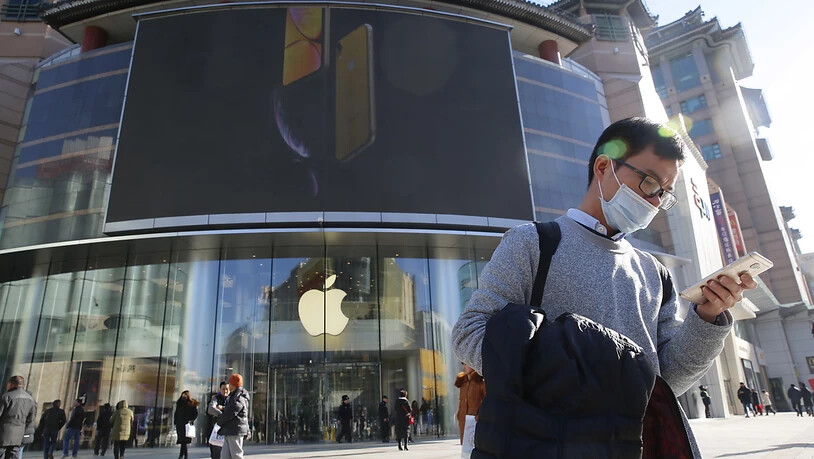 Apple stemmt sich gegen ein drohendes Verkaufsverbot in China: ein Mann in Hong Kong mit seinem Smartphone.
