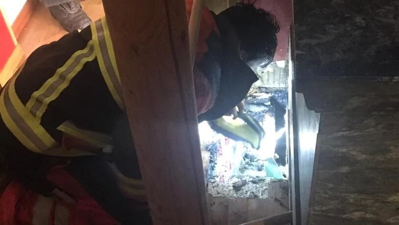 Ein Feuerwehrmann an einem aufgebrochenen Boden in Ruschein.