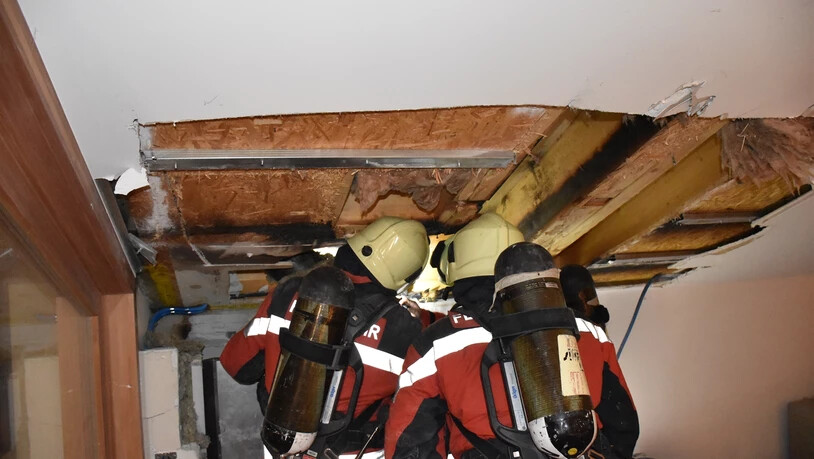 Feuerwehrleute an einer aufgebrochener Decke in Vals.