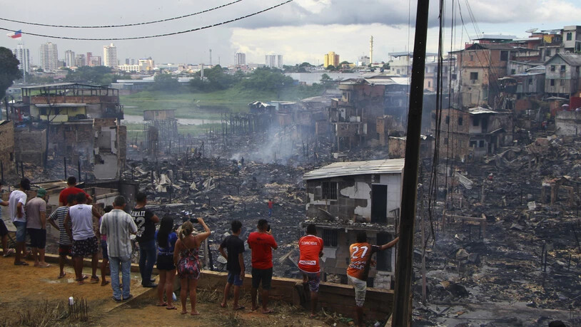 Nach einem Grossbrand in einem Armenviertel in Brasilien am Dienstag können die Bewohner nur noch die Überreste ihrer Häuser ansehen.