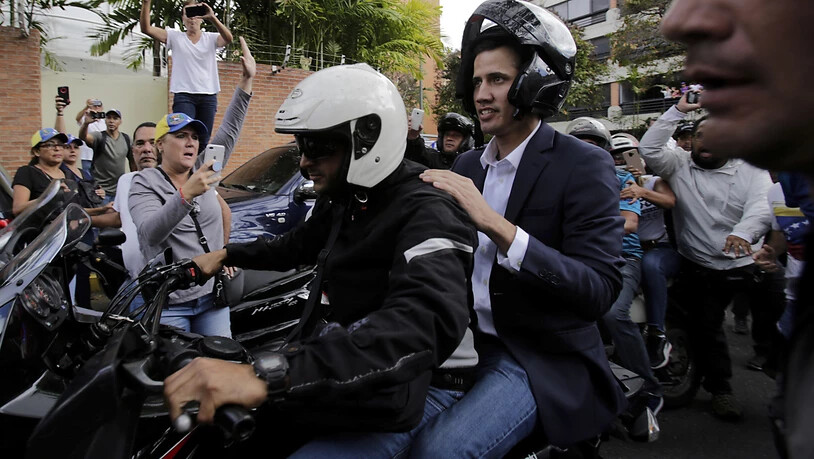 Oppositionsführer Juan Guaidó fährt auf dem Rücksitz eines Motorrads, nachdem er sich zuvor zum Staatspräsidenten erklärt hatte.