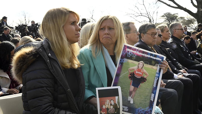 Zwei Zuhörerinnen an US-Präsident Trump Notstandsrede mit Fotos von Familienmitgliedern, die von Gewalt durch illegale Immigranten betroffen waren.