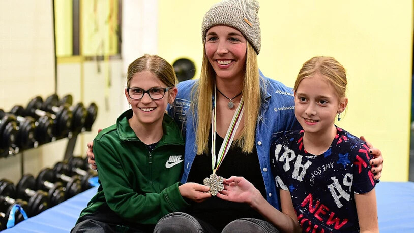 Gefragtes Sujet: Ladina Jenny posiert mit Medaille und zwei jungen Fans für ein Erinnerungsfoto.