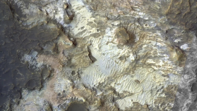 Eingefärbtes Bild des Bodens des Kibuye-Kraters in der
Region Terra Sirenum. Die Tönungen zeugen von der
reichen Vielfalt der mineralogischen Zusammensetzung
dieser Felsen. Chloridsalz und Tonmineralien wurden
hier aus dem Orbit mit Infrarotspektrometern…