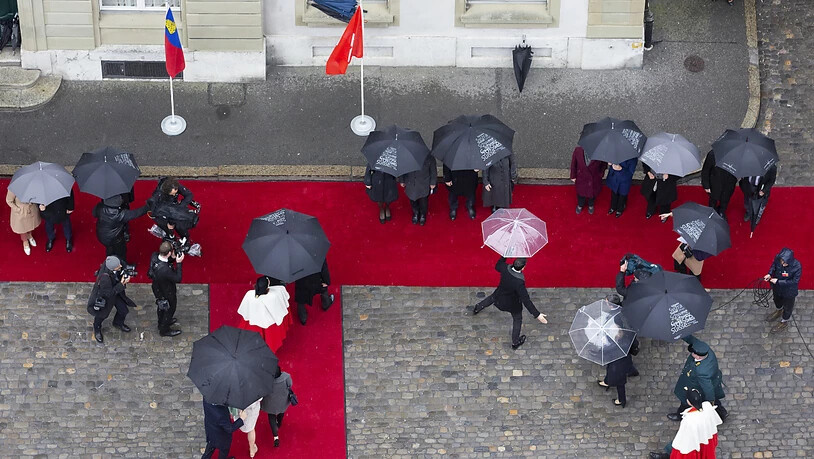 Mit Schirmen auf dem Roten Teppich: Das Erbprinzenpaar, die Schweizer Landesregierung, Weibel und andere Offizielle beim Staatsempfang.