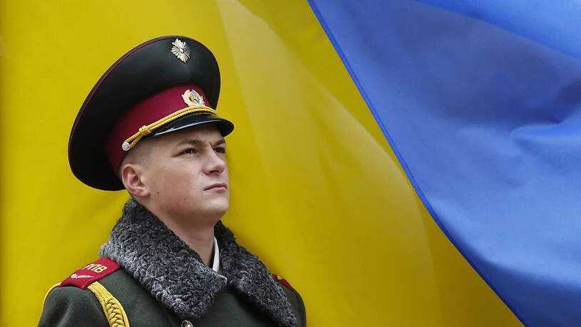 Ein ukrainischer Soldat steht Wache vor einer Landesfahne in Kiew. (Archivbild)