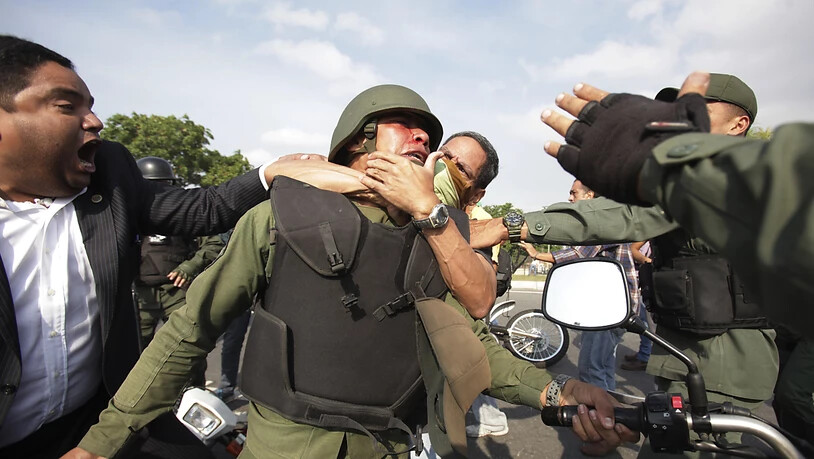 Demonstranten nehmen ausserhalb des Luftwaffenstützpunktes La Carlota bei Caracas einen Maduro-treuen Nationalgardisten in den Schwitzkasten.