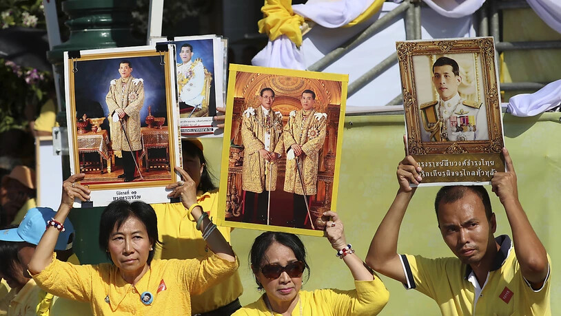 Lang lebe der König: Monarchisten in gelben Hemden halten Porträts ihrer neuen Königs in die Luft.