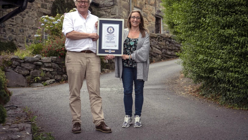 Zwei Anwohner stehen mit dem Rekord-Zertifikat auf der steilsten Strasse der Welt: Die Ffordd Pen Llech hat eine Steigung von 37,45 Prozent.