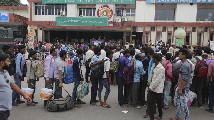 Indische Gastarbeiter in der Region machen sich nach dem umstrittenen Entscheid der indischen Regierung vom Bahnhof in Jammu aus auf den Weg nach Hause. (Archivbild)