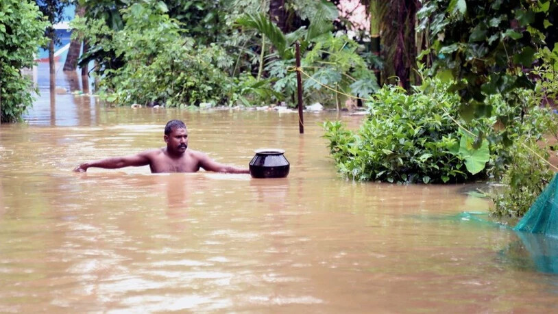Ein Mann watet durch eine überflutete Strasse in der Stadt Kochi im Bundesstaat Kerala.