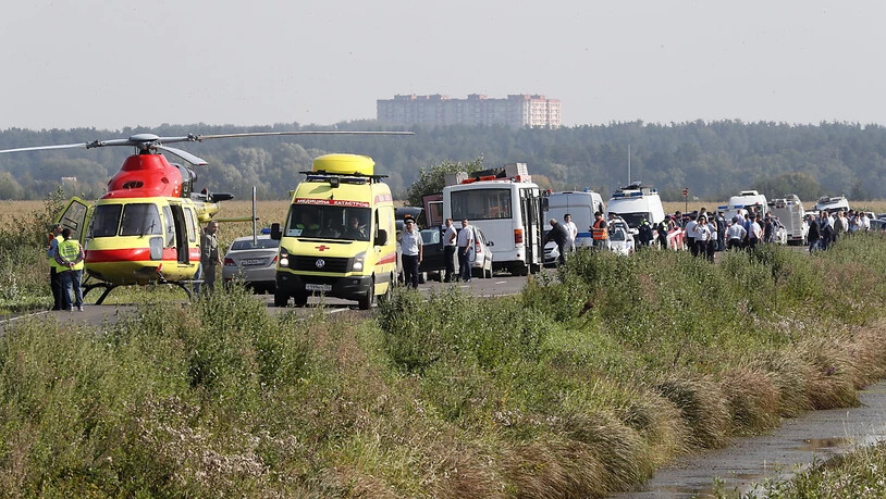Rettungsfahrzeuge und Helikopter in der Nähe des Maisfeldes, in dem der verunglückte Airbus der Ural Airlines liegt.