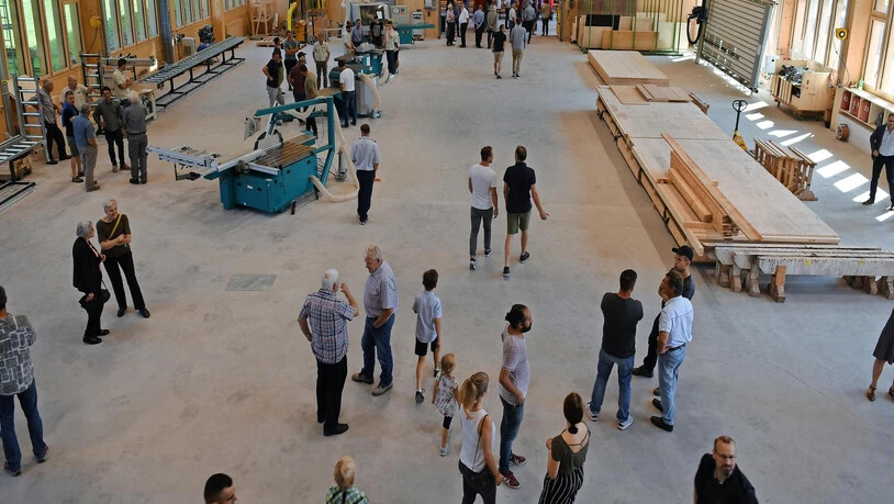 Blick in die neue Schreinerei: Eine Besuchergruppe lässt sich beim Rundgang durch das neue Gebäude die vielen neuen Maschinen erklären. 