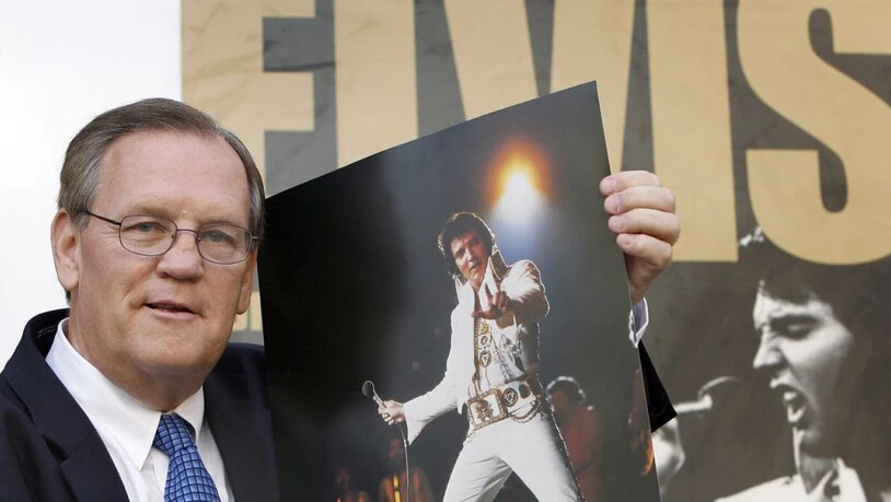Der Elvis-Fotograf Ed Bonja posiert am 13. Aug. 2007 in Berlin mit einem Foto des "King of Rock 'n' Roll" vor einem Ausstellungsplakat. Im September 2019 ist Bonja im Alter von 74 Jahren gestorben. (Archiv)