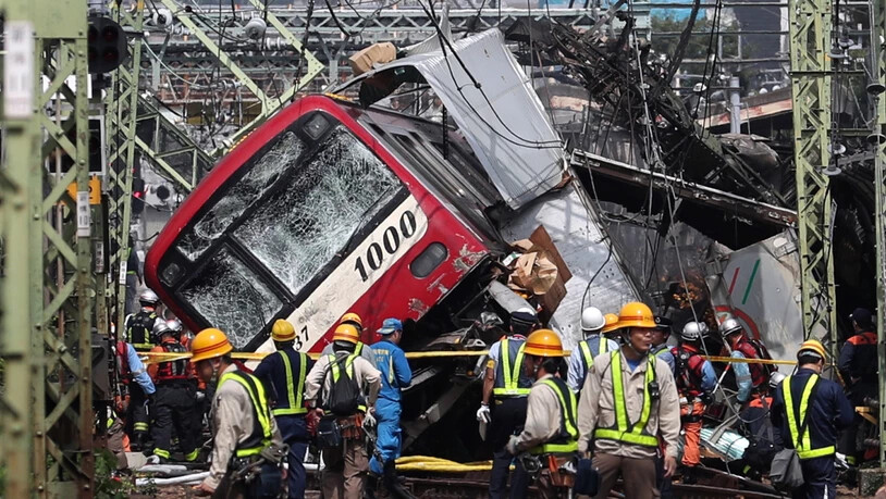 Rettungsarbeiten nach der Kollision eines Zugs mit einem Lastwagen auf einem Bahnübergang in der Nähe von Tokio.