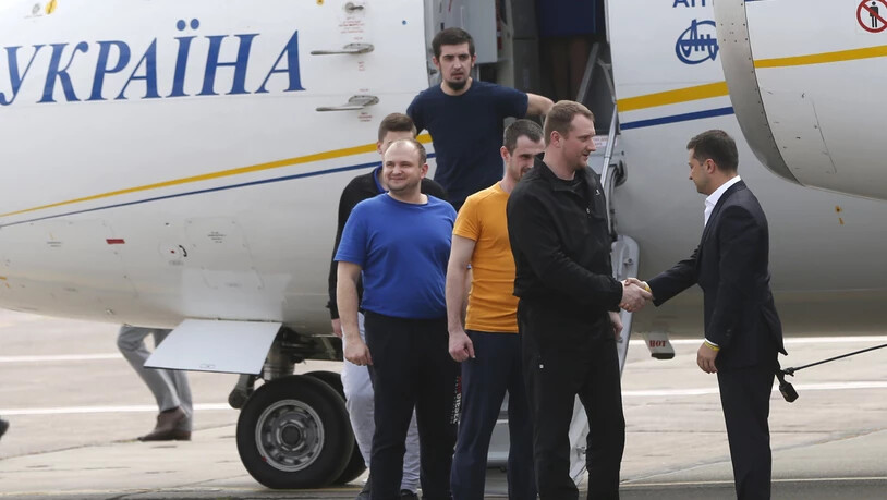 Der ukrainische Präsident Wolodymyr Selenskyj (r) nahm die ukrainischen Freigelassenen persönlich auf dem Rollfeld in Kiew in Empfang.
