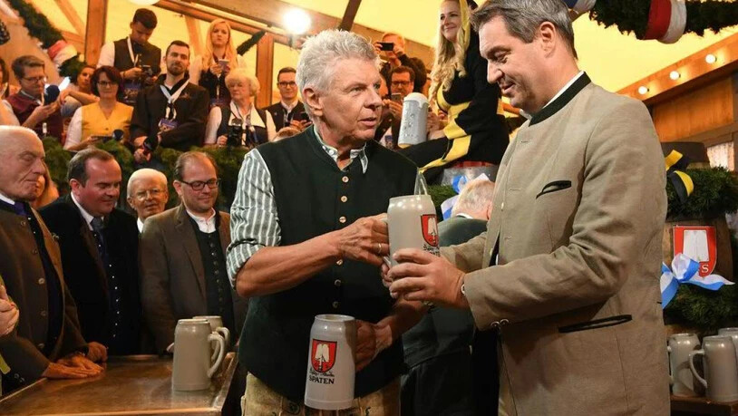 Der Münchner Oberbürgermeister Dieter Reiter überreicht dem bayerischen Ministerpräsidenten Markus Söder nach dem traditionellen Fassanstich einen Masskrug.