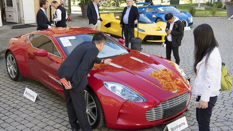 Ob das Kleingeld reicht für diesen roten Aston Martin One-77 Coupé aus dem Jahr 2011? Dahinter ein gelber LaFerrari-Ferrari und ein blauer Bugatti Veyron.