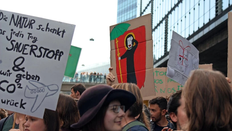 Eines der Plakate, das die Glarner Gruppe zur Klima-Demo nach Bern trägt, zeigt den Landespatron, der unter der Erderwärmung leidet.