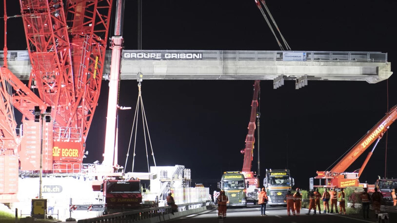 Ein riesiger Kran stand in der Nacht auf Dienstag im Waadtland im Einsatz. In Bursins ersetzten 60 Bauarbeiter eine alte Autobahnbrücke über die A1 zwischen Lausanne und Genf.
