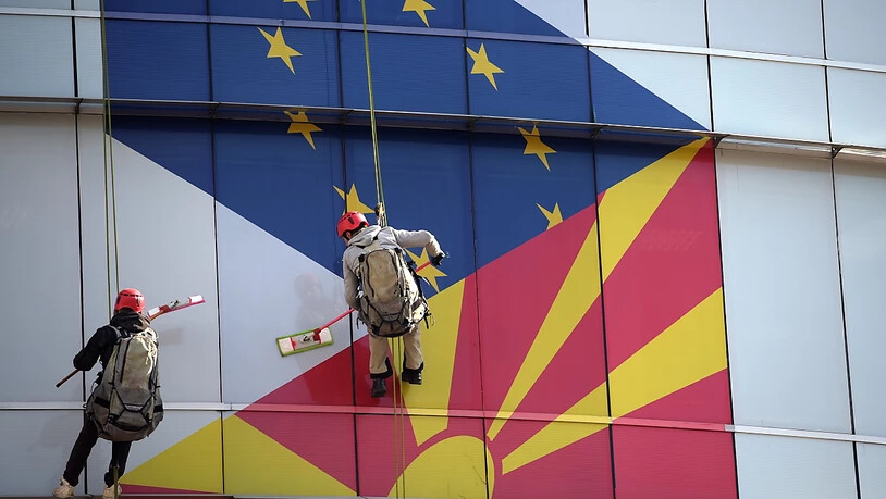 Arbeiter putzen die Fassade am EU-Büro in Skopje: Aufgemalt sind die Flaggen der EU und Nordmazedoniens.