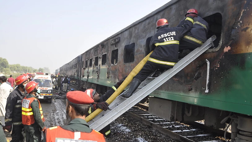 Rettungskräfte suchen nach Überlebenden des Brandes im Zug.